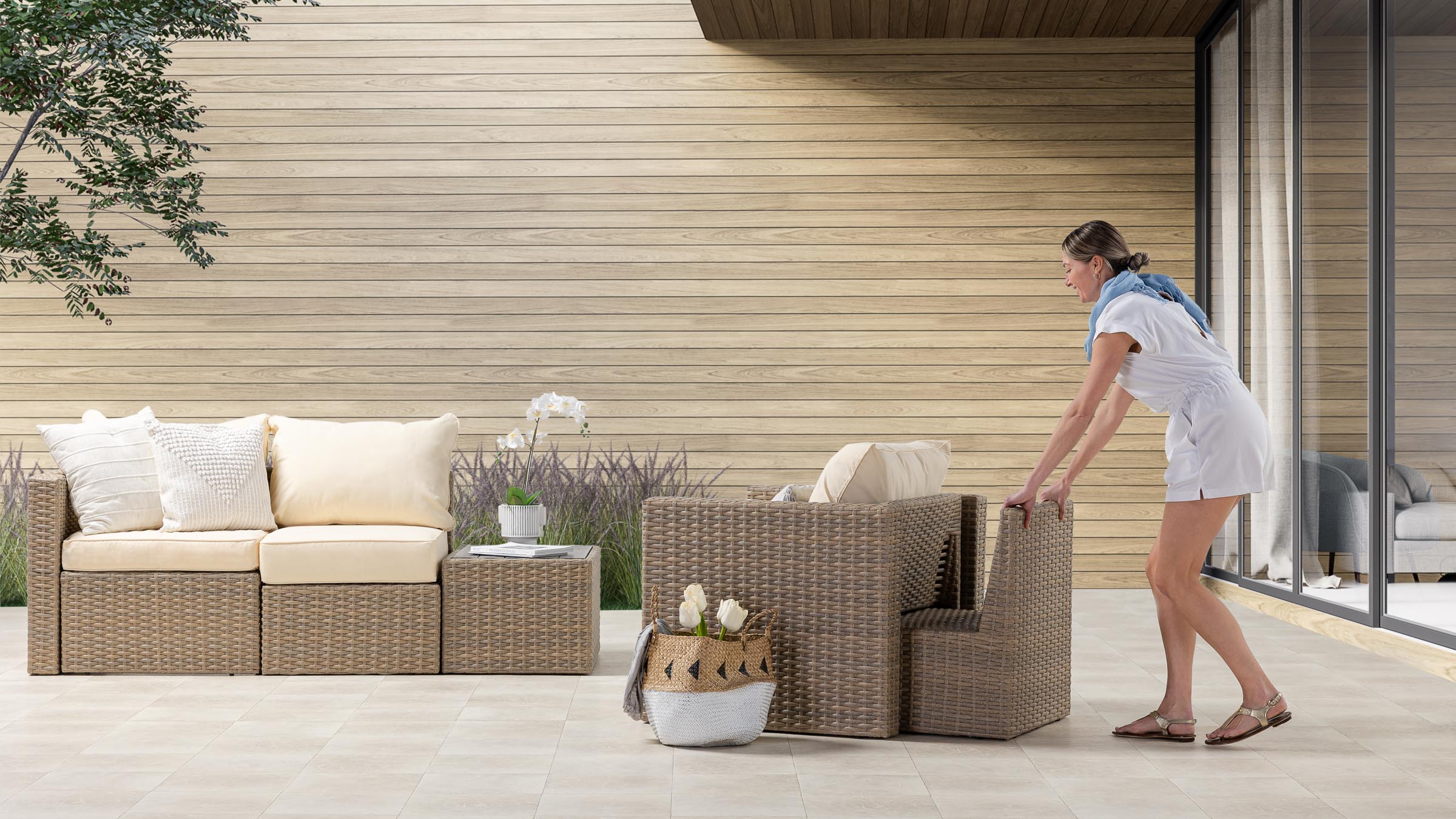 A lady moving around some backyard furniture.