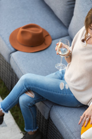 A lady sitting on a patio couch outside