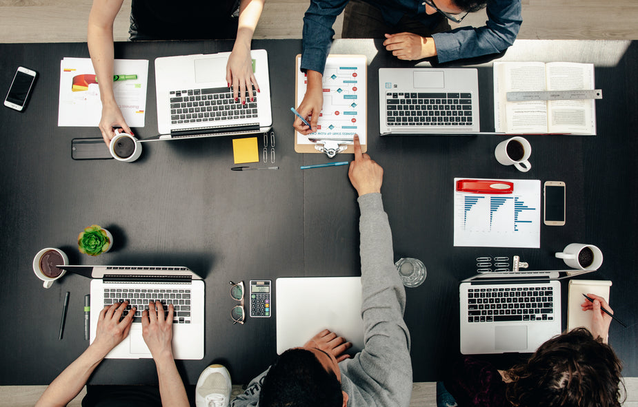 Co-workers at a large table from above.