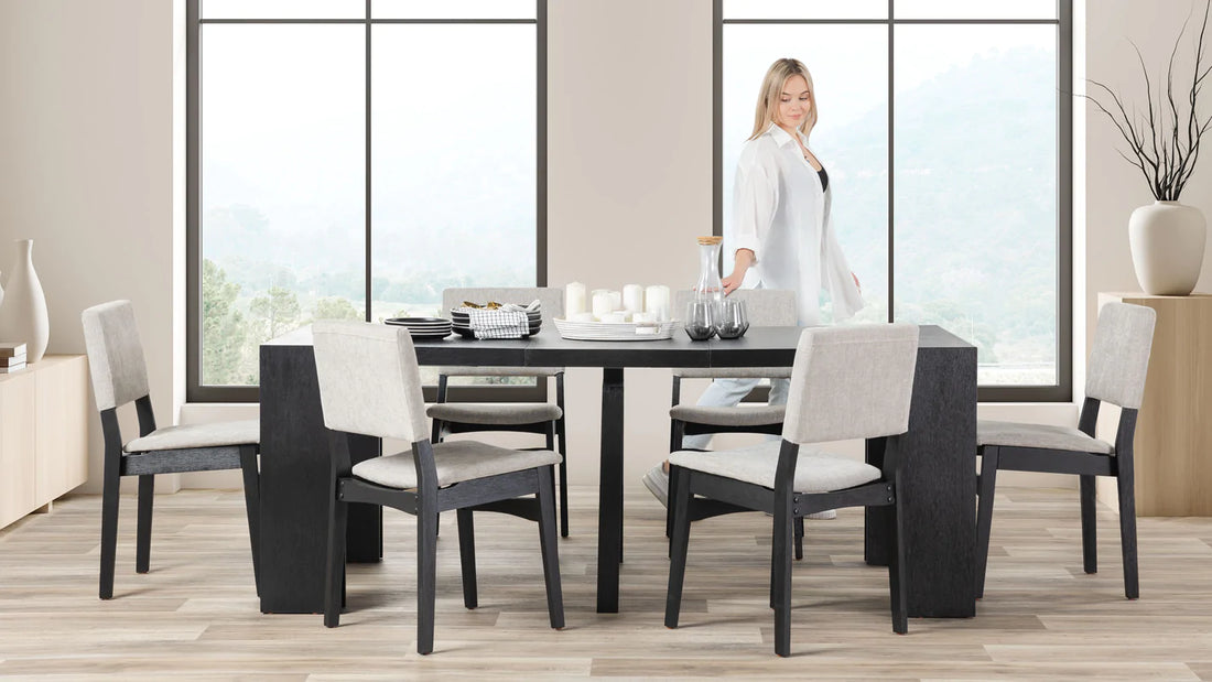 A lady standing at a extendable table in a living room.