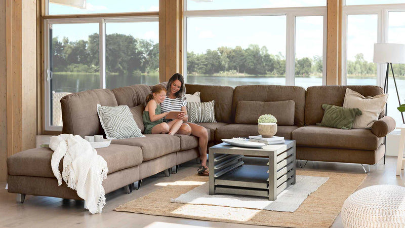 A mother and daughter sitting on a large couch.